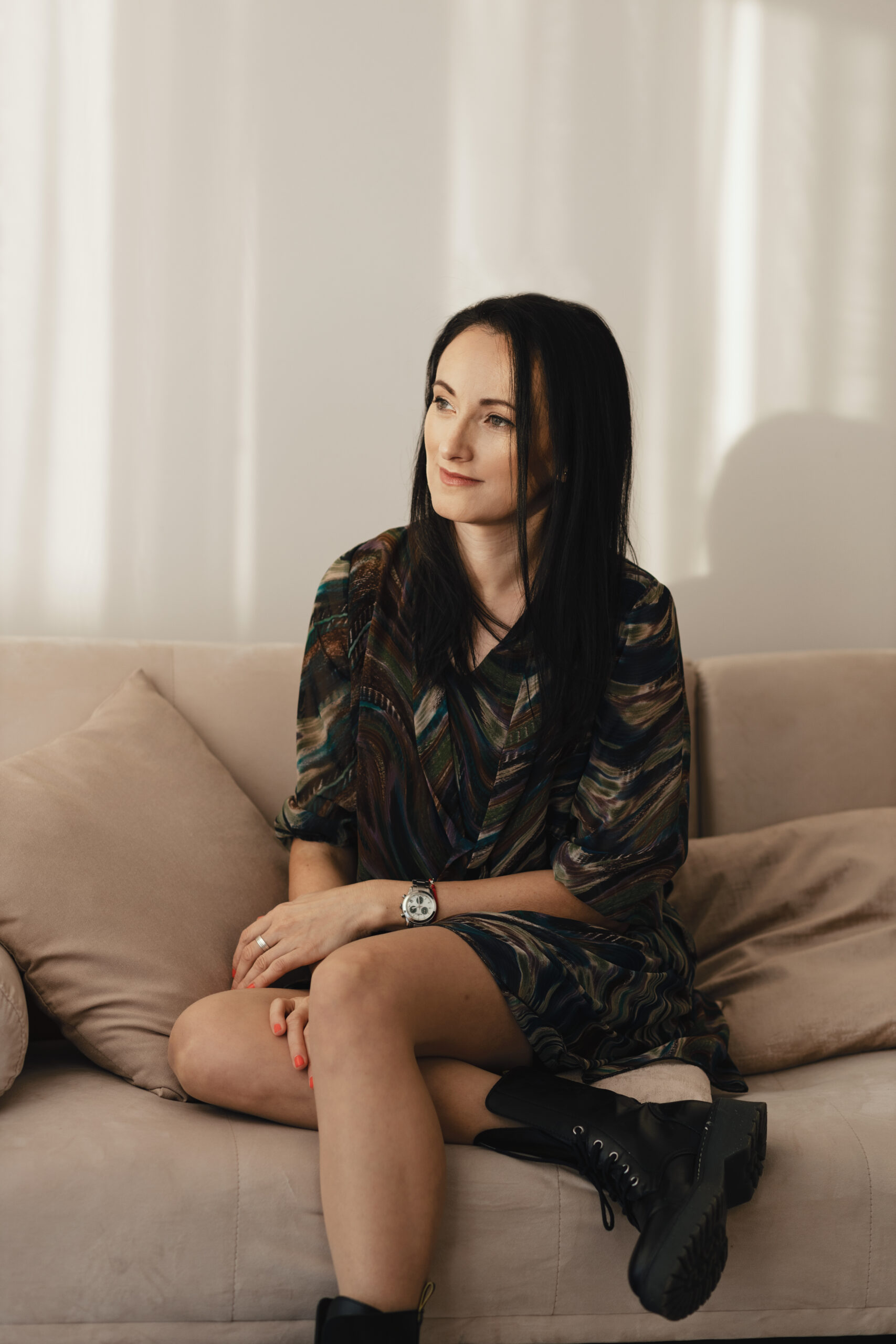 Kobieta siedzi na sofie i patrzy w okno